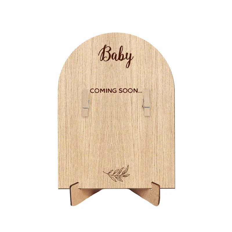 A light wood photo frame with the word Baby engraved on the top and Coming Soon on the bottom.