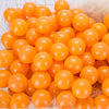 A pile of bright orange, spherical plastic balls for kids' play areas.
