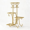 A gold-colored metal corner plant stand with four tiers for indoor and outdoor use.