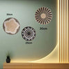 Three round boho straw wall hangings of varying sizes are displayed on a light green wall with vertical lighting.
