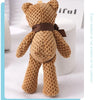 A handcrafted, textured brown stuffed bear key pendant with a dark brown ribbon around its neck.