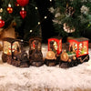 A set of miniature Christmas train music boxes with LED lights and water-filled crystal balls resting on snow.