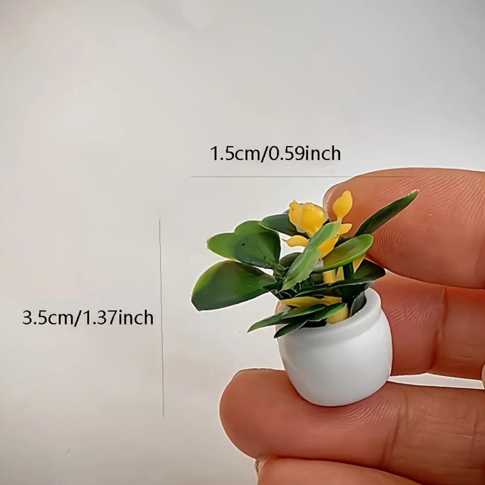 A small potted plant with yellow flowers is held in a hand, showing its size relative to a finger.