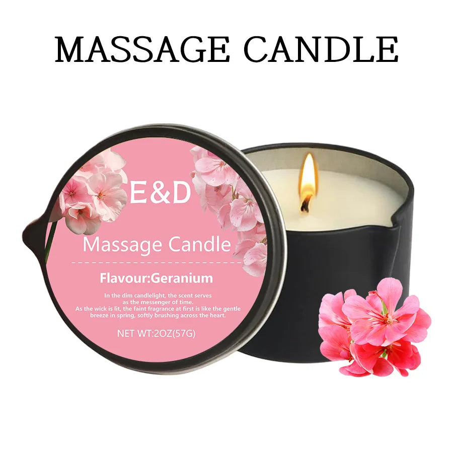 A black jar of a Geranium massage candle with a lit wick and pink flower petals.