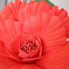 A close-up of a vibrant red artificial peony flower with tiny red beads in the center.