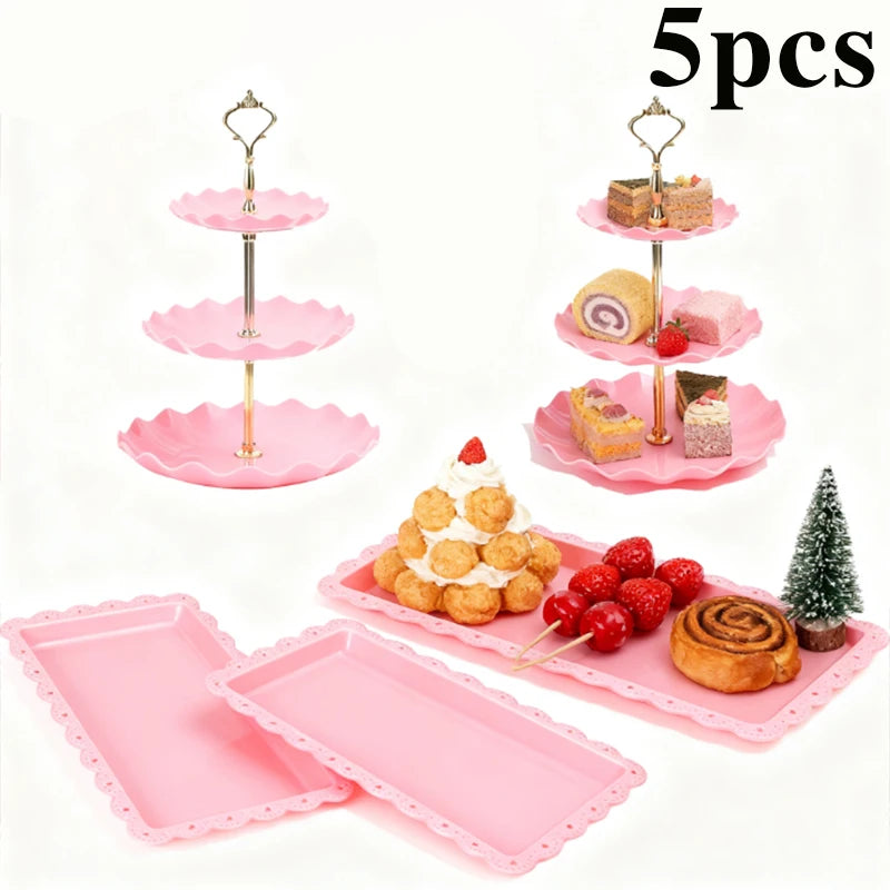A pink three-tier dessert rack with various baked goods and candies displayed on the tiers.