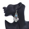 Boucles d'oreilles en pièces de monnaie turquoise bohèmes argentées, présentées sur une oreille de mannequin noire.