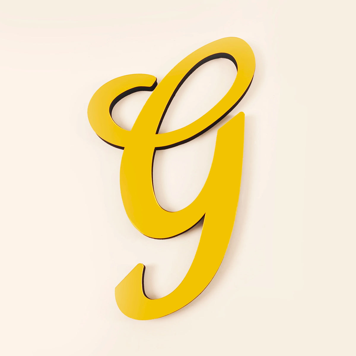 A bright yellow 3D acrylic letter G wall sticker against a plain background.