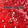 Red heart-shaped foil confetti scattered across a white background for parties and celebrations
