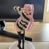 A figurine of an anime-style girl with pink hair wearing a striped sweater and black boots.
