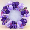 A circular arrangement of dark purple and light purple latex balloons used for party decor.