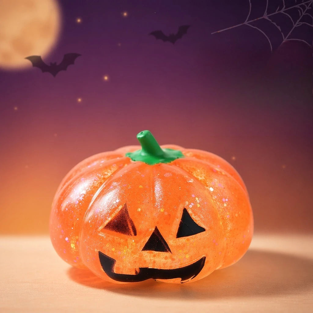 An orange Halloween pumpkin stress ball with a carved face sits on a wooden surface against a dark purple background.