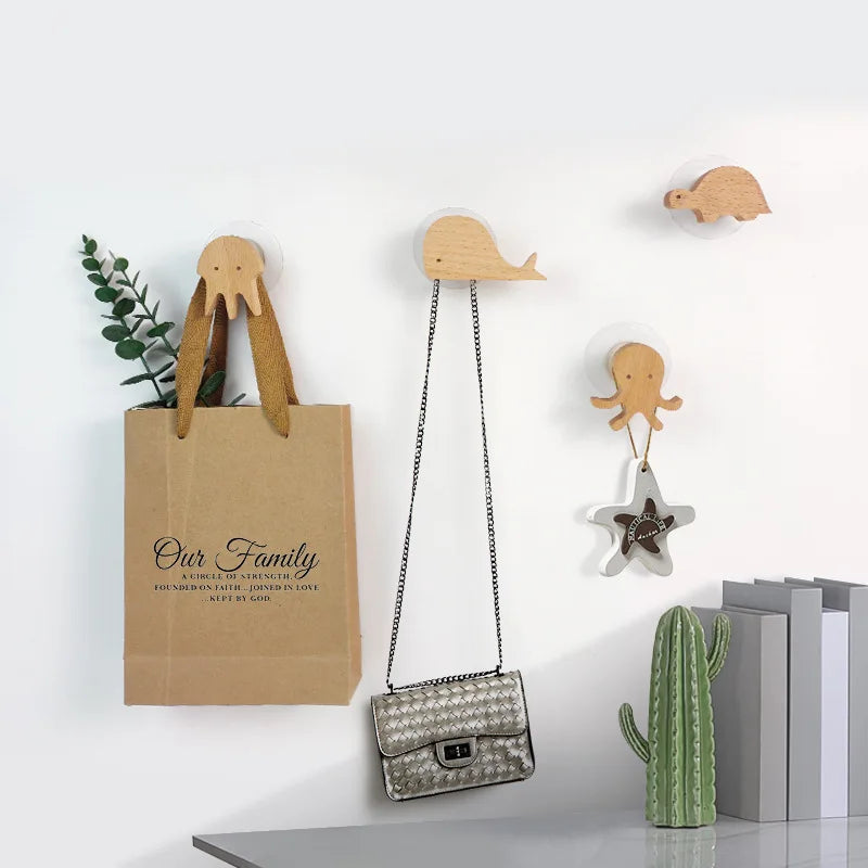 Decorative wooden animal hooks hanging on a wall, including a duck, a frog, and a lizard.