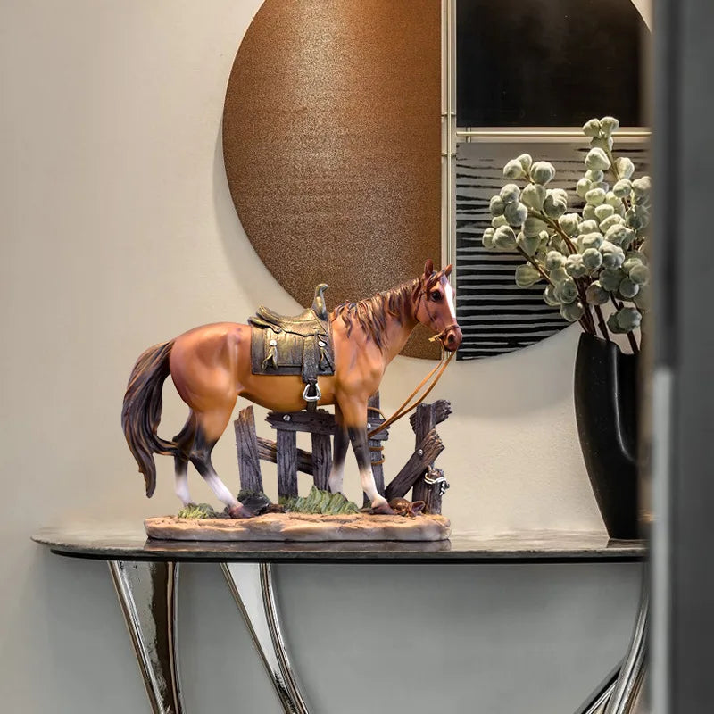 A rustic western horse sculpture with a brown coat and a saddle standing on a wooden fence piece.