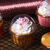A close-up of a cupcake in a golden greaseproof liner filled with white frosting and colorful sprinkles.