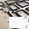 A set of 13 wooden picture frames in black and white displayed on a light surface.