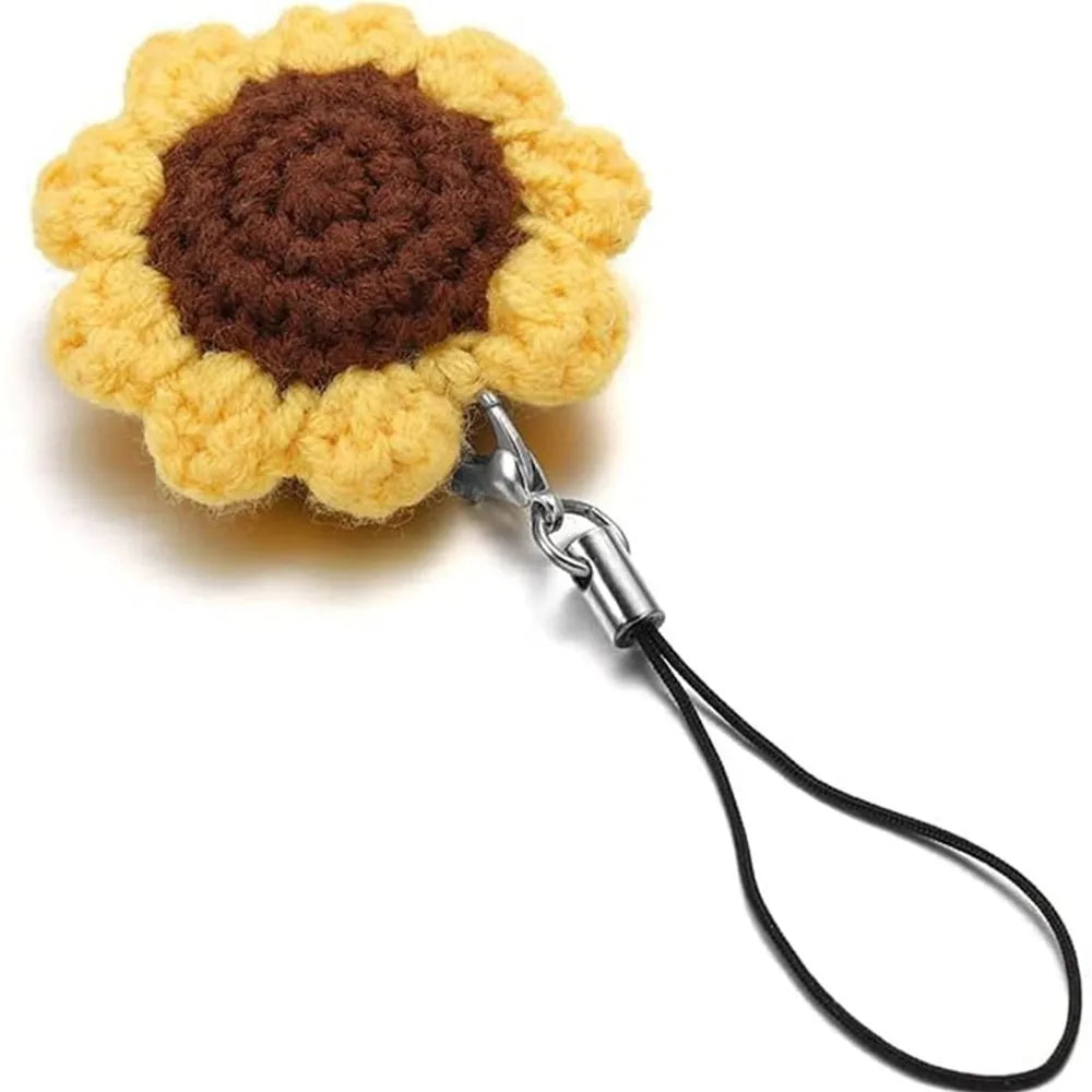 A handcrafted flower made of yellow and brown yarn attached to a silver lobster clasp lanyard.