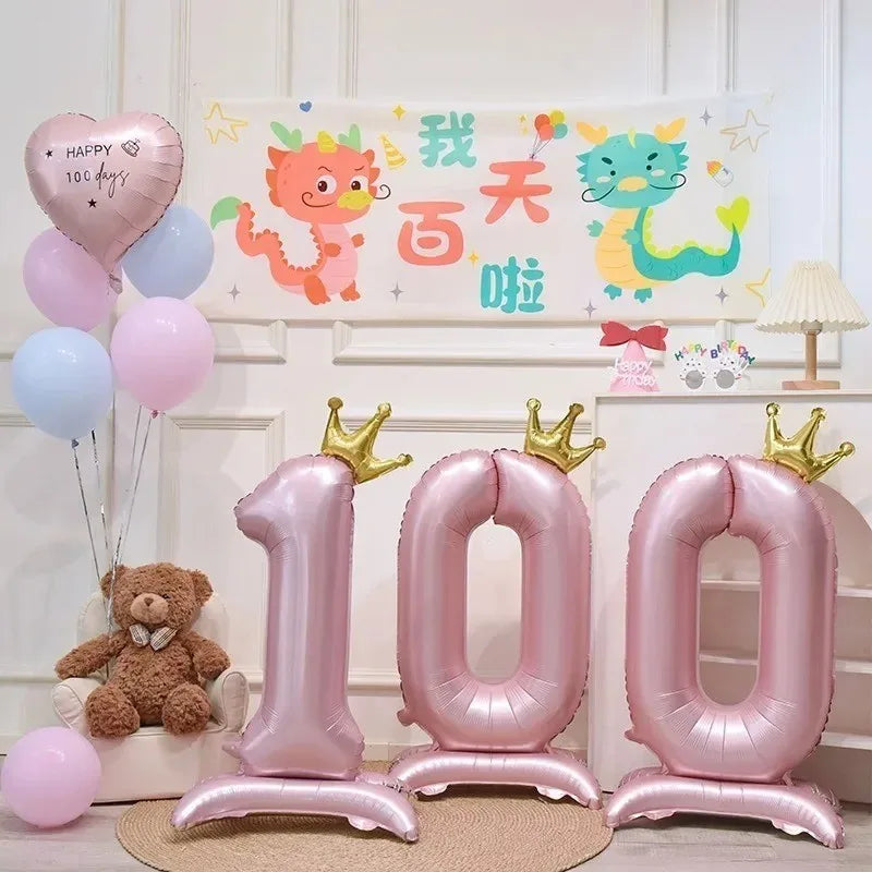 Pink aluminum foil crown number balloons spelling out 100
