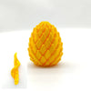 A bright yellow 3D printed dragon egg fidget toy shown from the top and a side view.