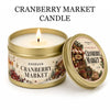 A jar of Cranberry Market scented candle in a gold tin with a lid and gift box.
