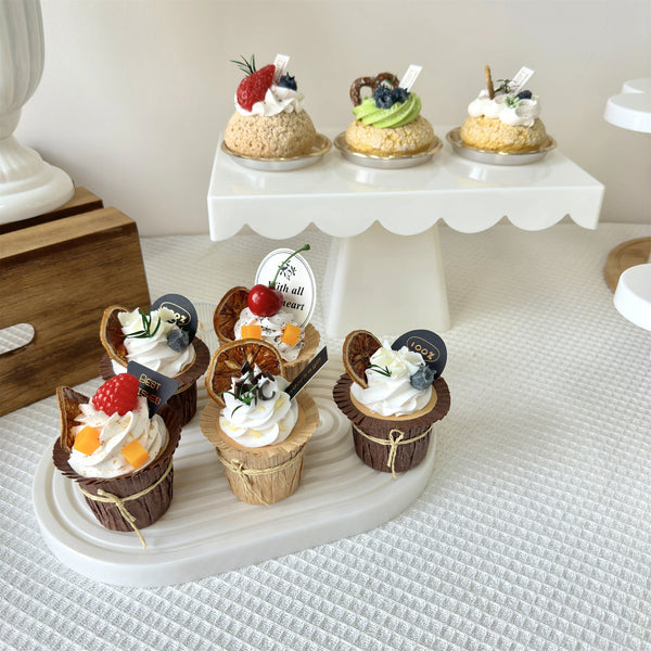 A set of two pink cupcake stands decorated with various colorful cupcakes and toppings.