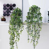 Artificial eucalyptus hanging plant with green leaves displayed on a shelf.