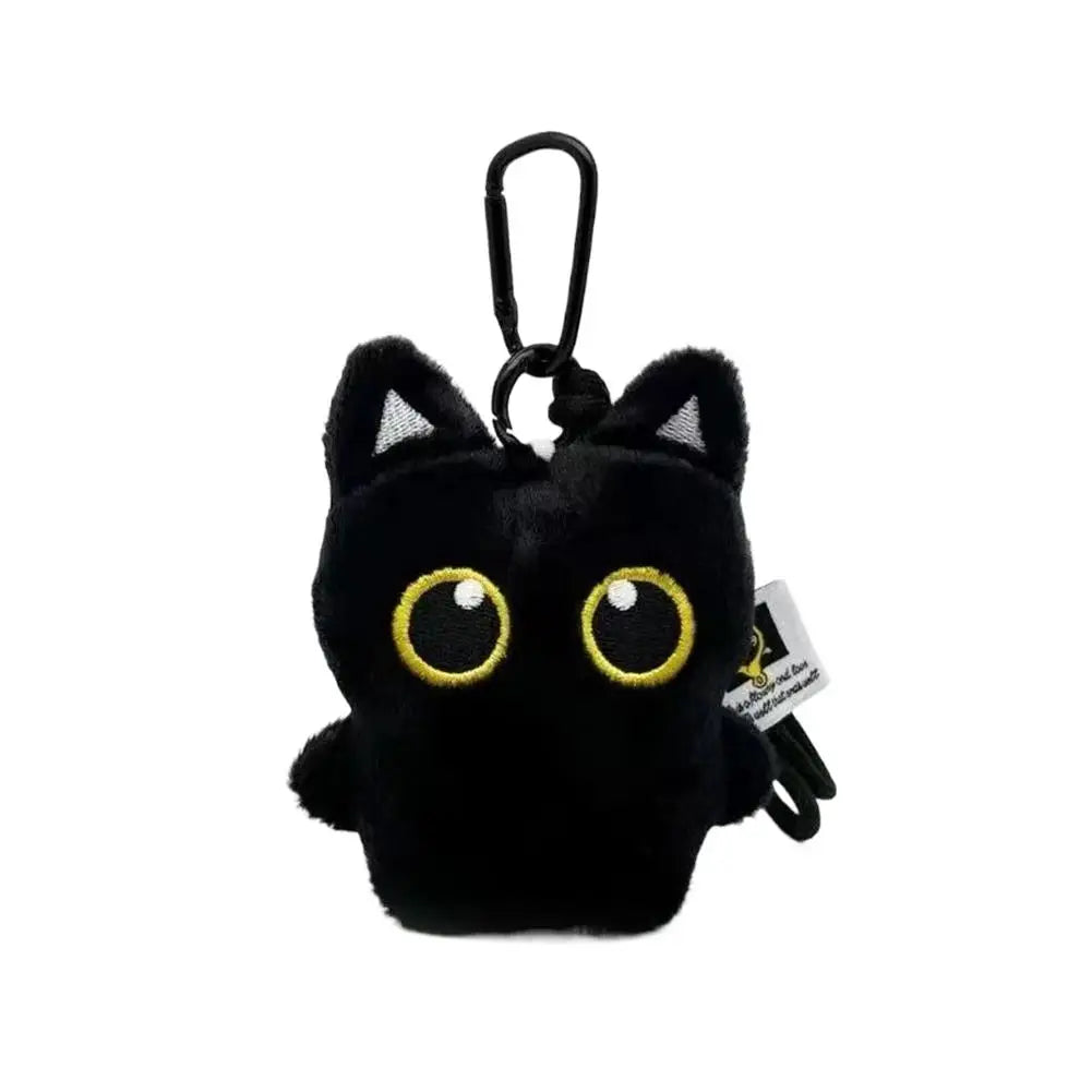 A black seal plush keychain with gold-yellow eyes and a metal loop.