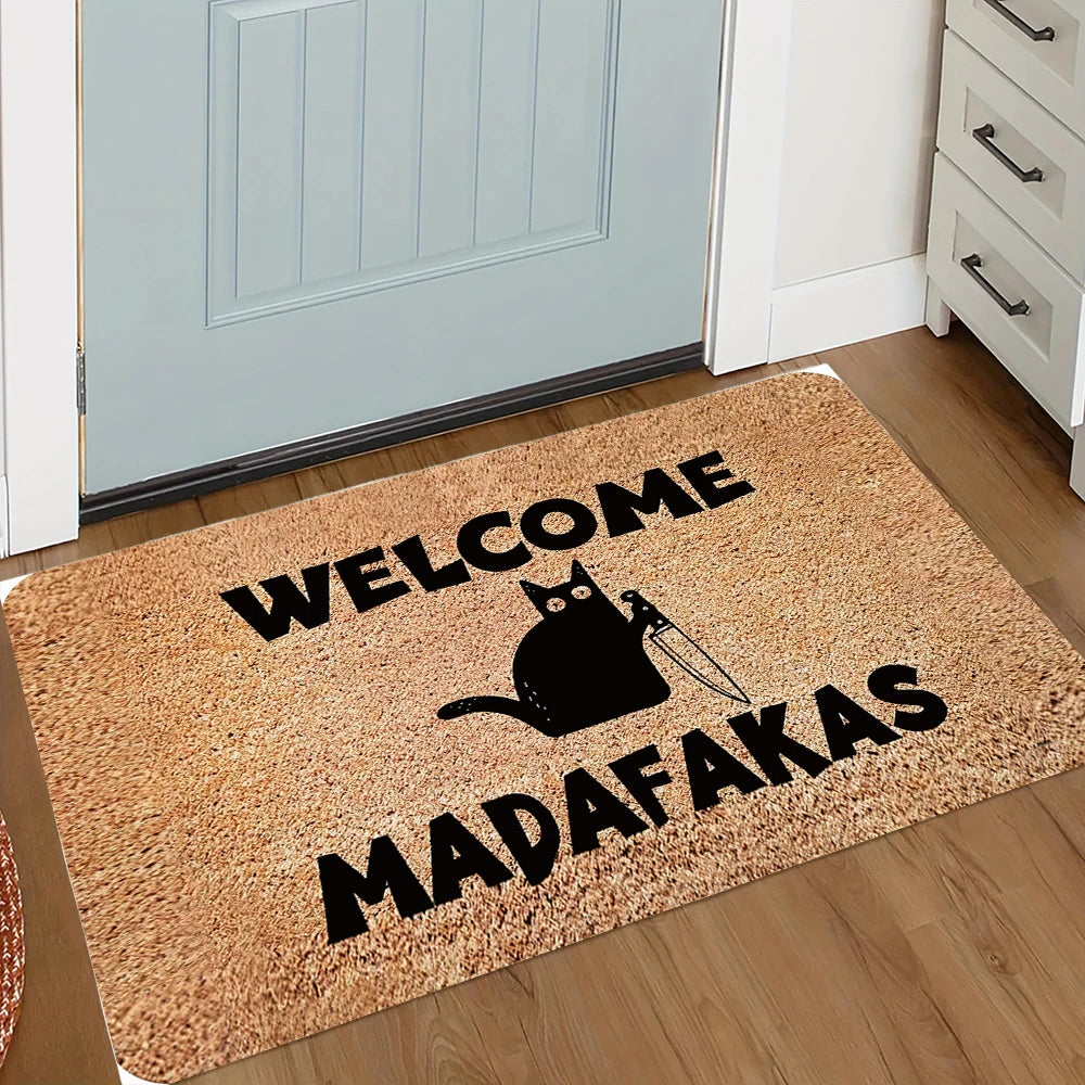 A rectangular, tan doormat with black text that reads WELCOME MADAFAKAS and features a silhouette of a cat with a knife.