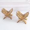 A pair of elegant wooden book stands shaped like open leaves for holding Quran and holy books.