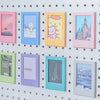 A collection of nine colorful magnetic photo frames in various pastel shades mounted on a white pegboard.