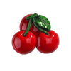 A cluster of bright red cherry-like fruit with a green leaf, used as a fridge magnet.