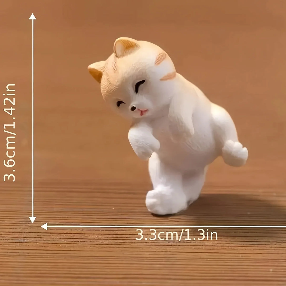 A white cat figurine with pink accents is shown against a wooden background, with dimension lines indicating its size.