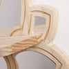 A close-up of a light wood decorative floating shelf with an arched cutout design.