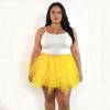 A woman models a white cropped top and a yellow tulle tutu skirt.