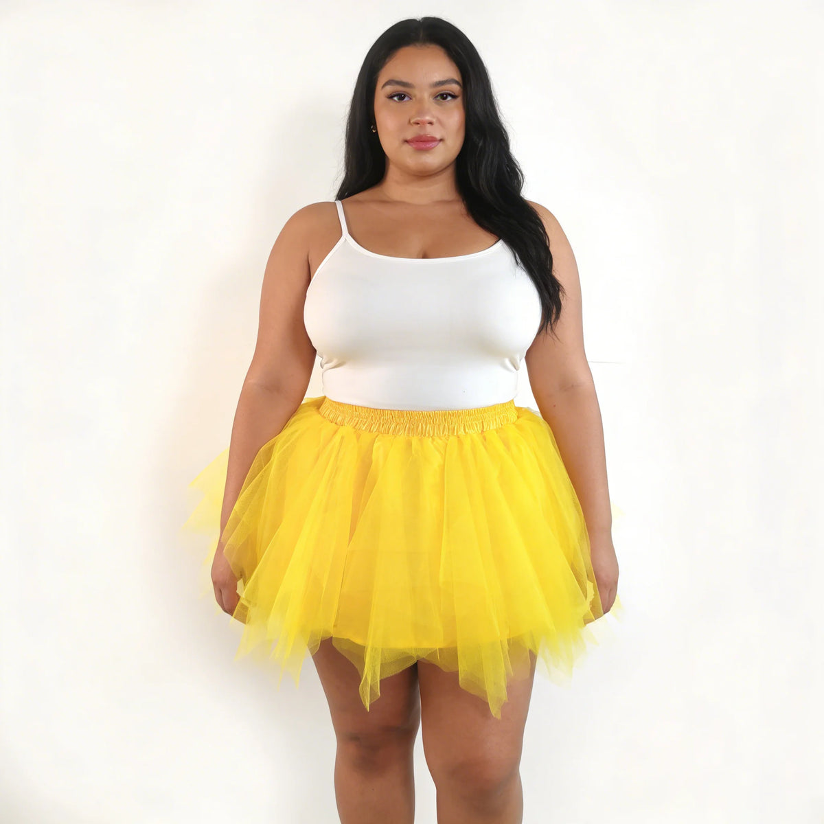 A woman models a white cropped top and a yellow tulle tutu skirt.