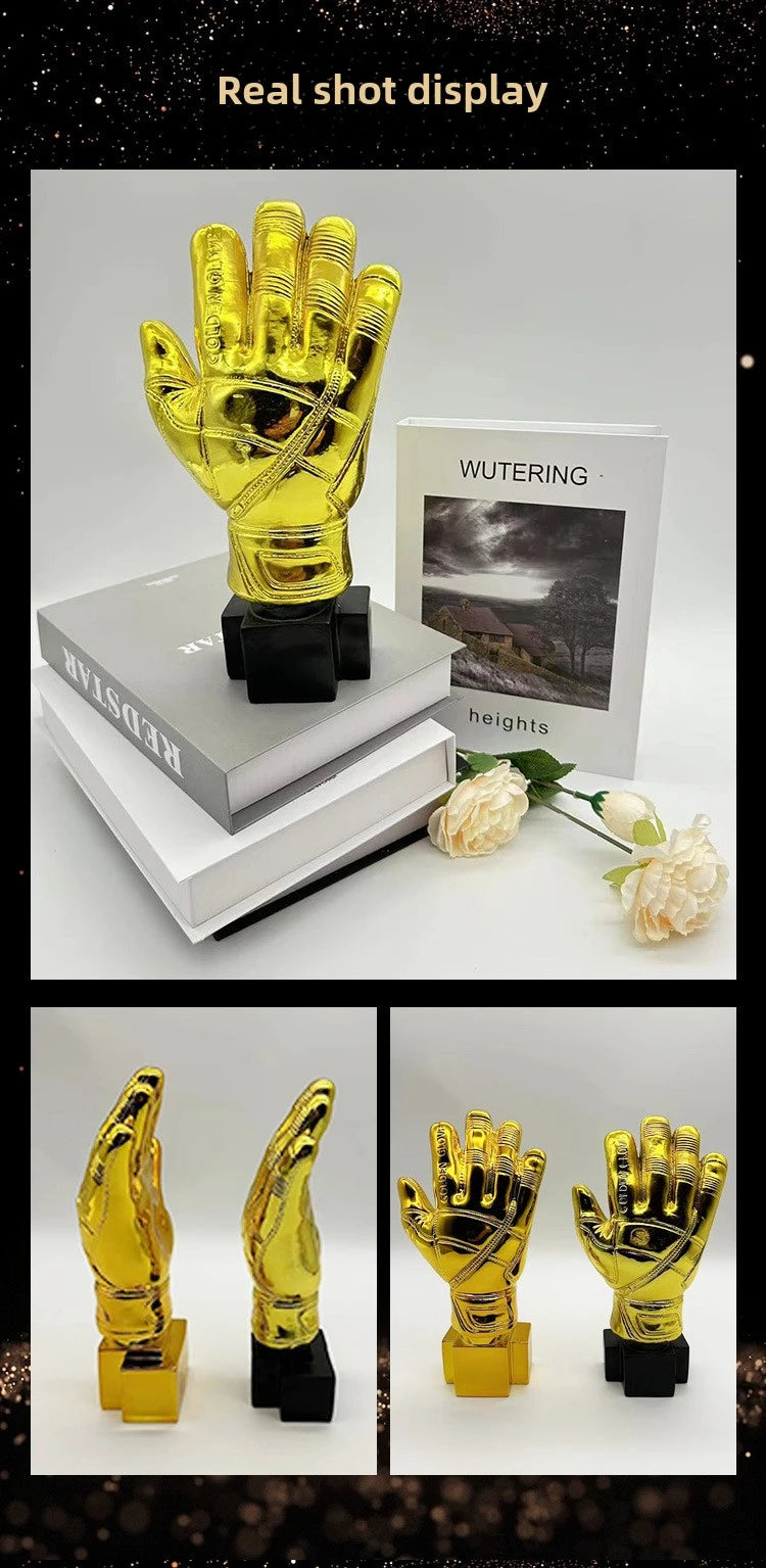 A display of golden gloves award trophies on a white background with a book and foliage.