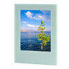 A light blue magnetic double-sided frame displaying a scenic view of the ocean and a tall green tree.