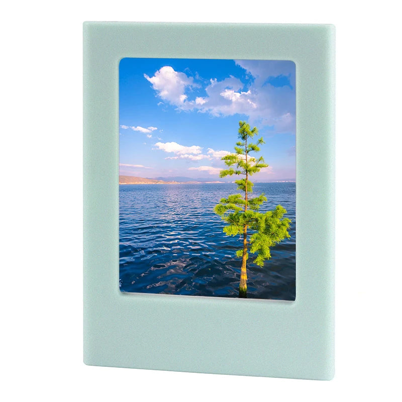 A light blue magnetic double-sided frame displaying a scenic view of the ocean and a tall green tree.