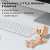 A small wooden figurine with a face is shown next to a laptop keyboard.