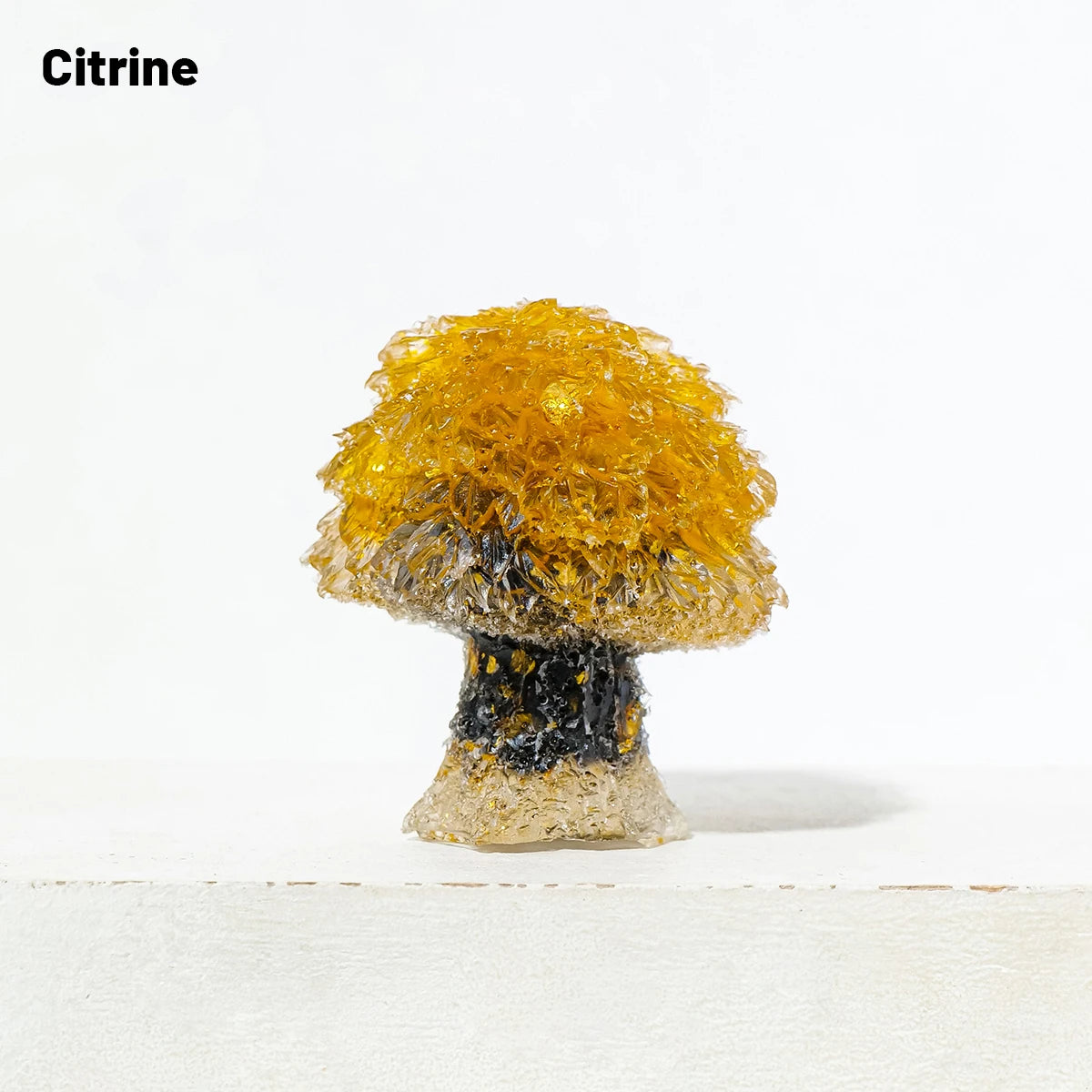A natural crystal mushroom tree sculpture featuring a bright yellow top and a dark base.