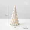 A white ceramic glow-in-the-dark mini Christmas tree decor with warm lights.