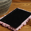A black resin picture frame shaped like a pink rose is displayed on a wooden surface.