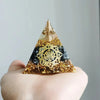 Handmade resin orgonite pyramid featuring natural obsidian and a copper coil