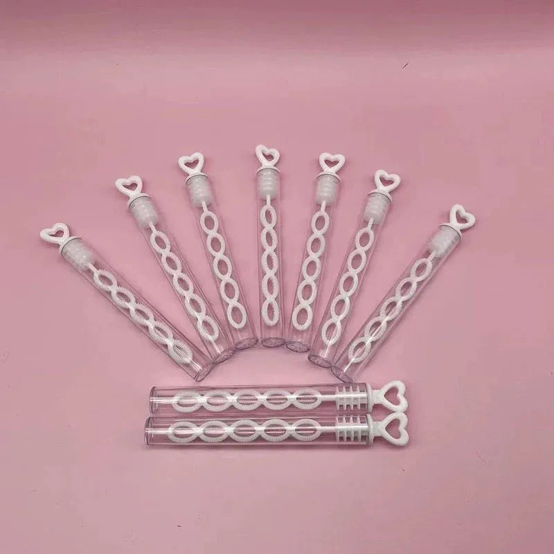 A collection of heart-shaped clear bubble wands arranged in a fan shape on a pink background.