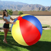 A woman stands next to a large inflatable pool party ball featuring red, yellow, and blue sections in an outdoor setting.