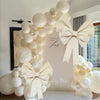 A white honeycomb ball decoration set featuring large round balloons and bow accents for a celebration.