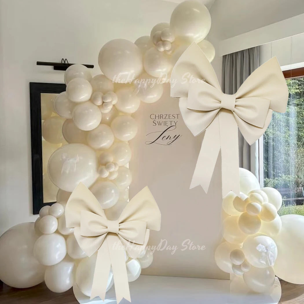 A white honeycomb ball decoration set featuring large round balloons and bow accents for a celebration.