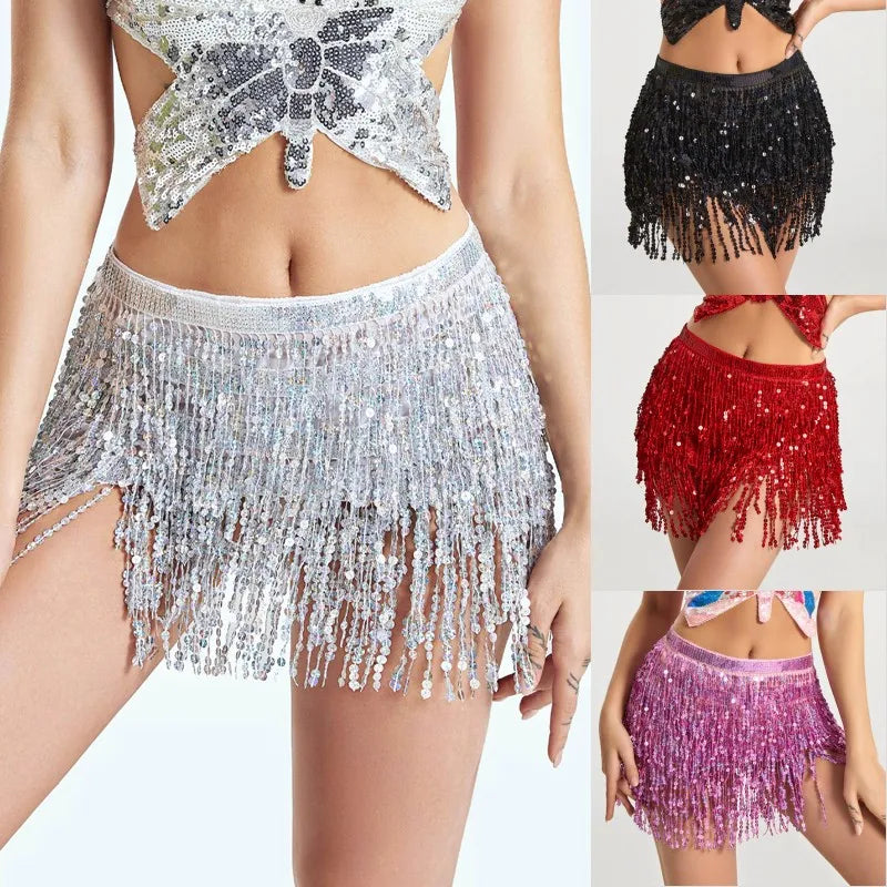 A woman models a sparkly silver hula dancer layer skirt with tassel belts and a black sequin skirt.