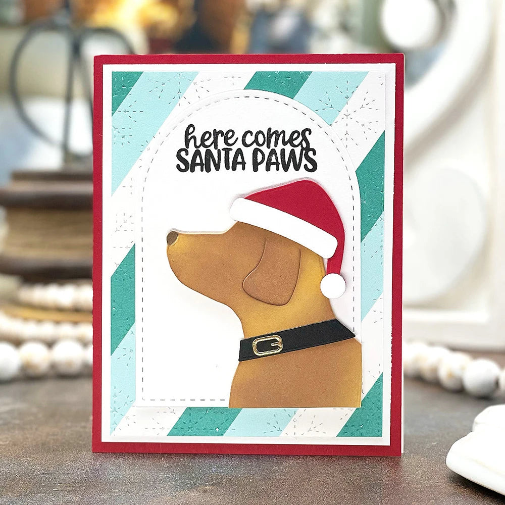 A card featuring a dog's head silhouette with Santa paws text and a red and green striped border