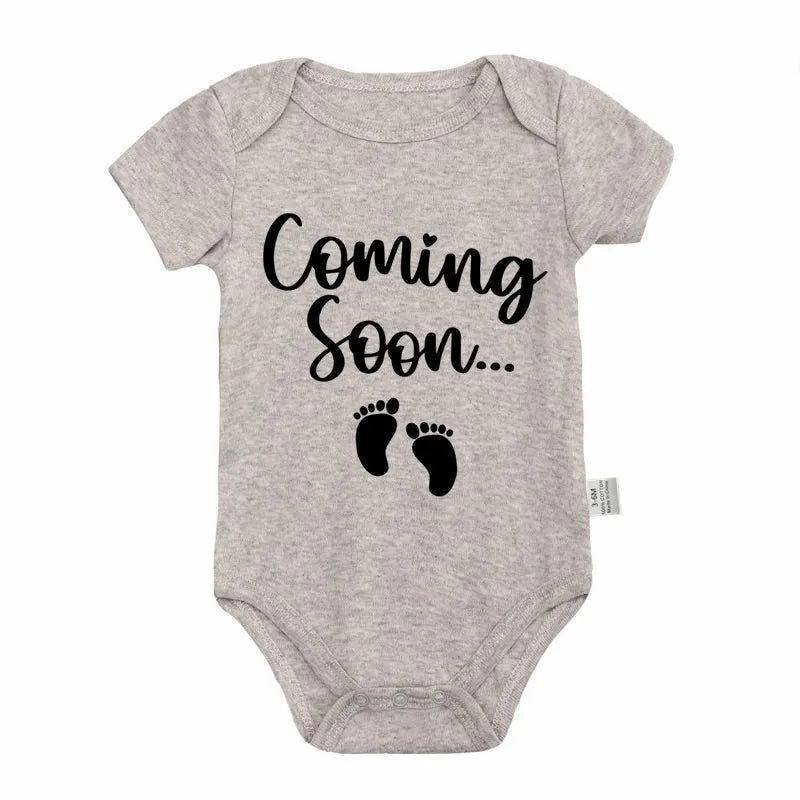 A gray baby bodysuit with the text Coming Soon on the front.